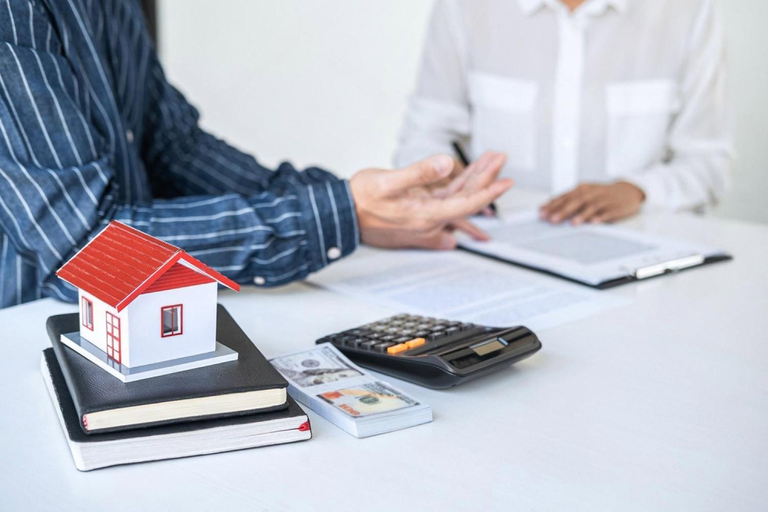 Insurance broker in Dubai reviewing a home policy with a client at a desk